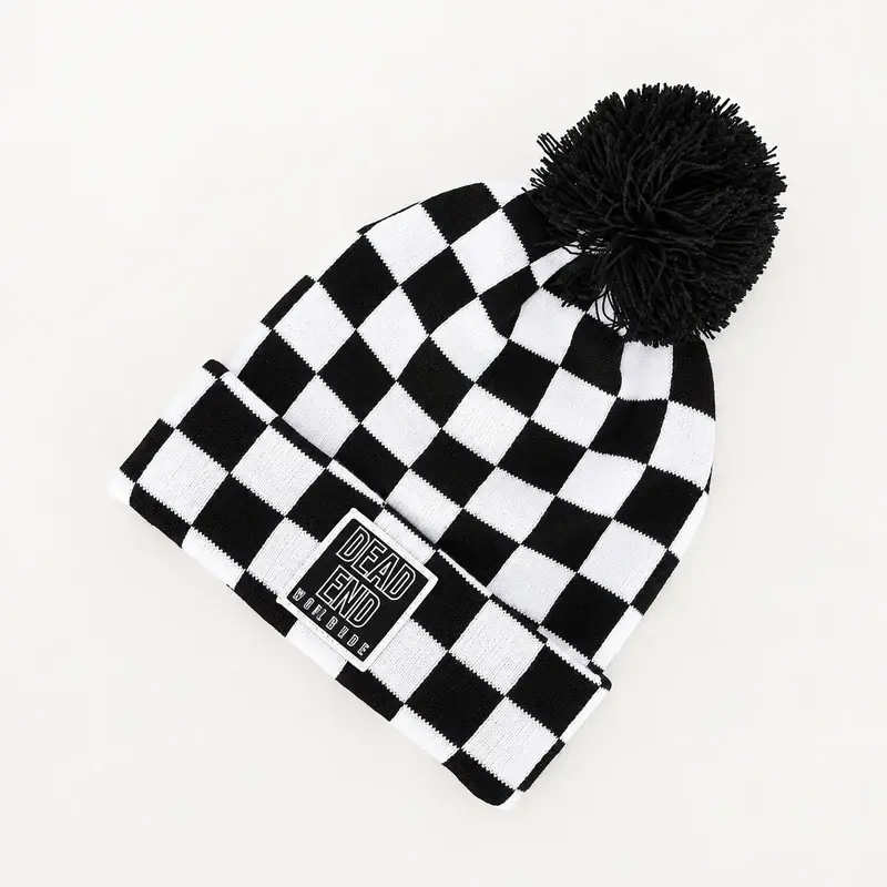 Black and white jacquard beanie with a dark pom