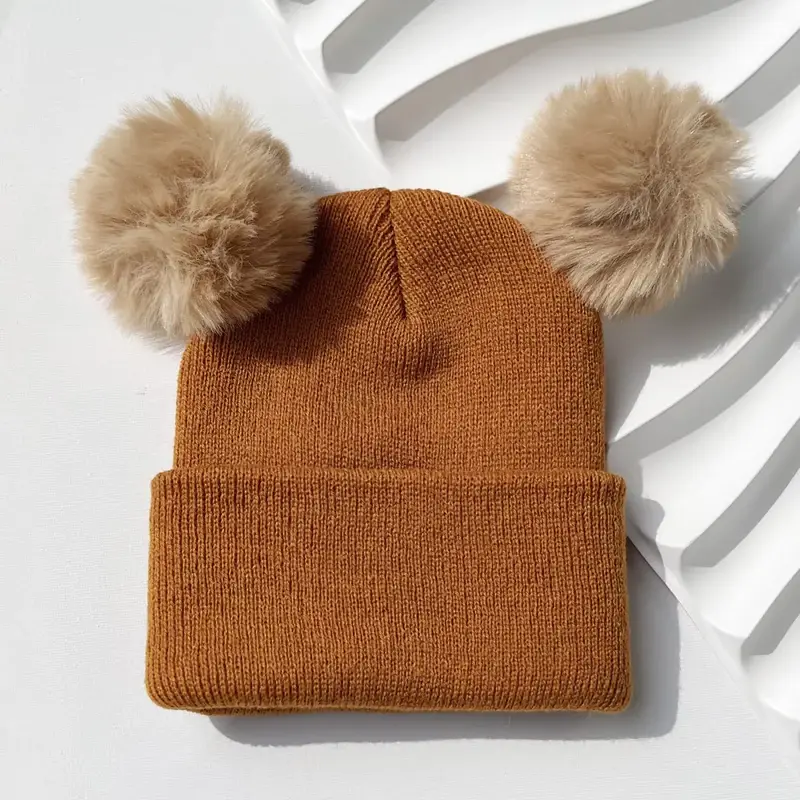 Brown cuffed beanie with two tan faux fur poms