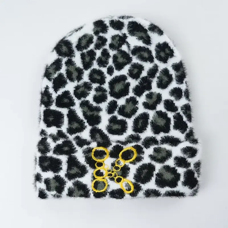 Black and white patterned cuffed beanie with a yellow embroidered motif