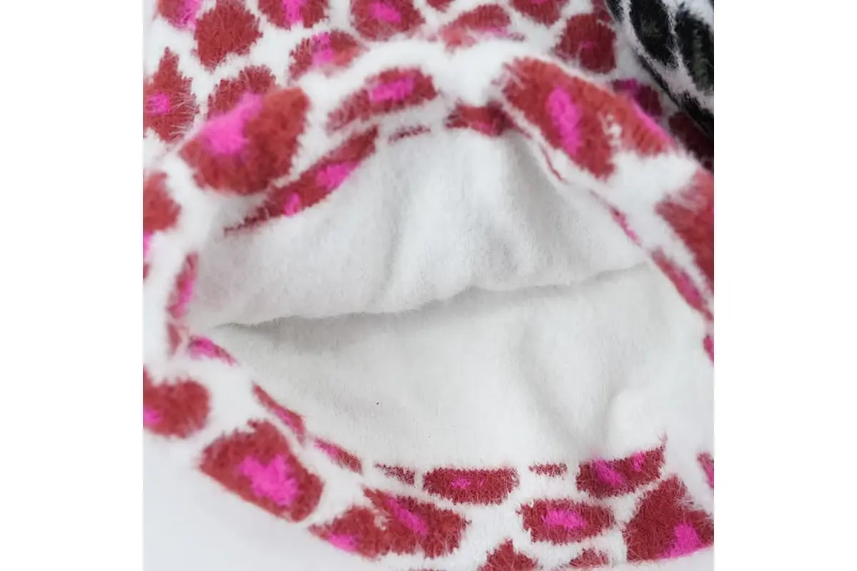 Close view of soft white lining inside a pink patterned beanie