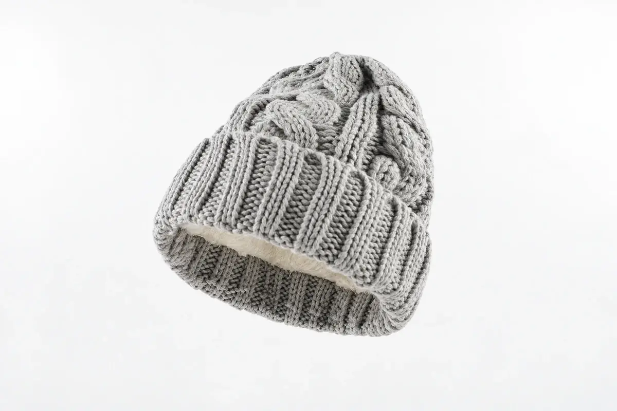 Gray cable-knit cuffed beanie showing the outer knit, cuff and fleece lining