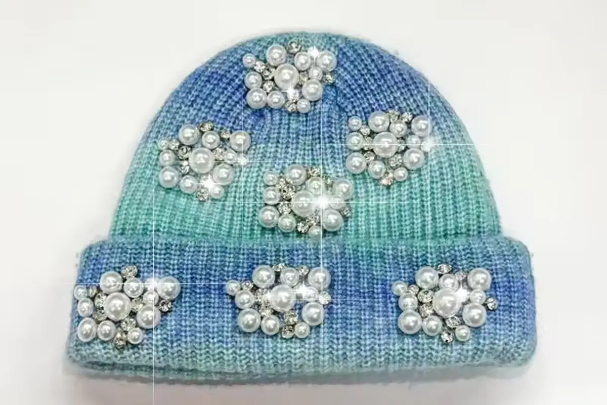 Aqua cuffed beanie with white pearl-like flower clusters on the crown and cuff