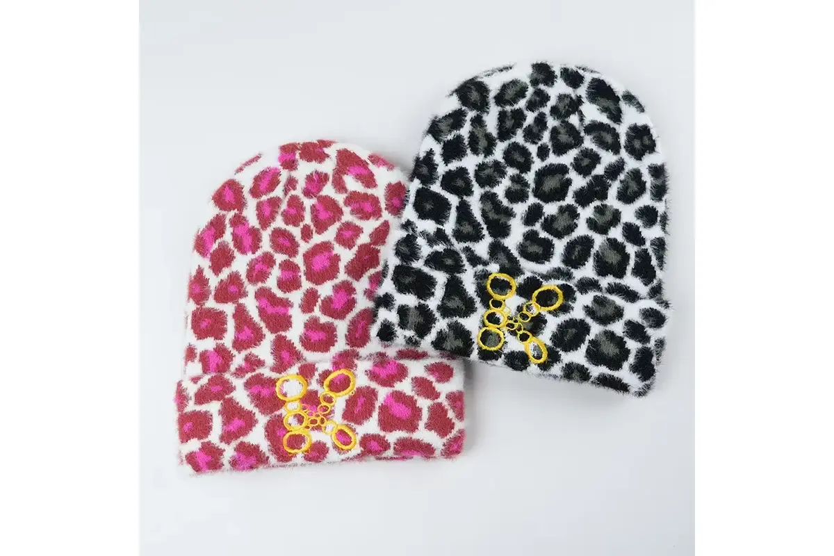 Two finished patterned cuffed beanies in pink and black