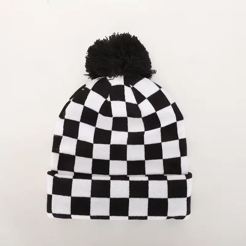 Black-and-white checkerboard knit beanie with a black pom