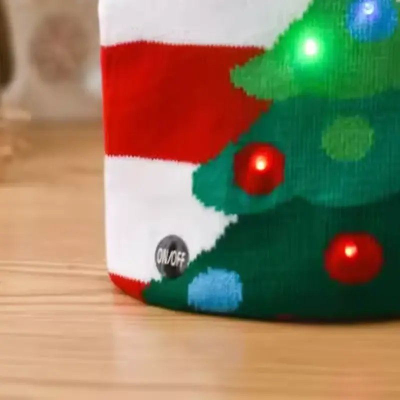 Close-up of the ON/OFF switch and lit tree on the Christmas beanie