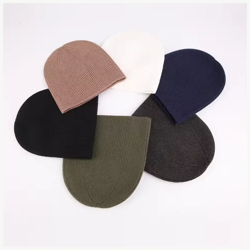 Plain cuffless knit beanies arranged in five neutral colors