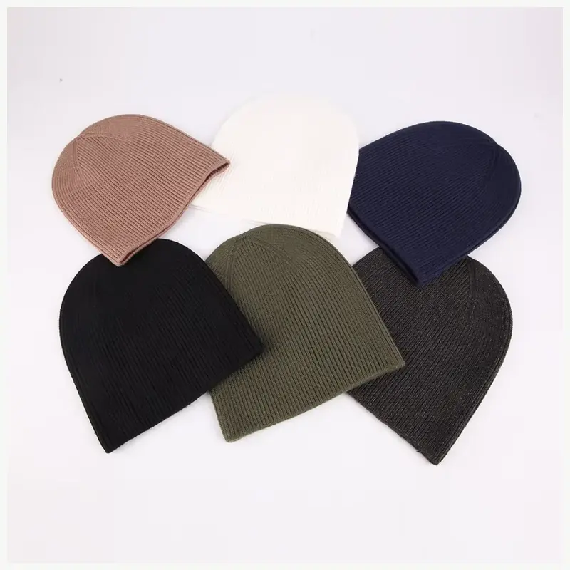 Plain cuffless knit beanies arranged to show color and knit options