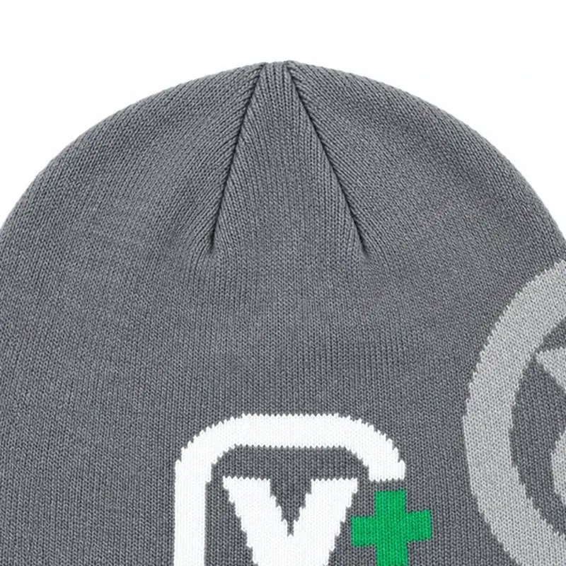 Detail of the white knit mark on a gray cuffless beanie