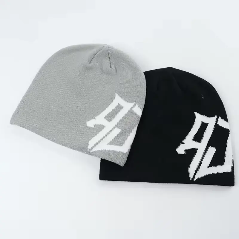 Two cuffless knit beanies in gray and black, each with a white V-shaped knit mark