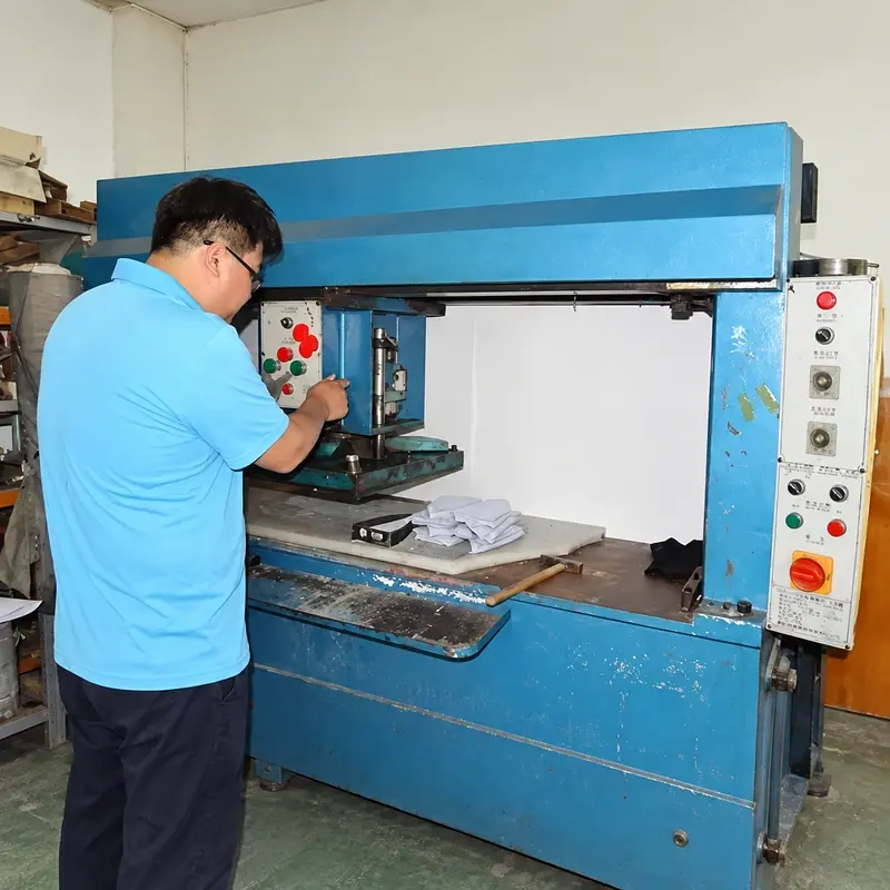 Worker operating industrial equipment in a beanie production workshop