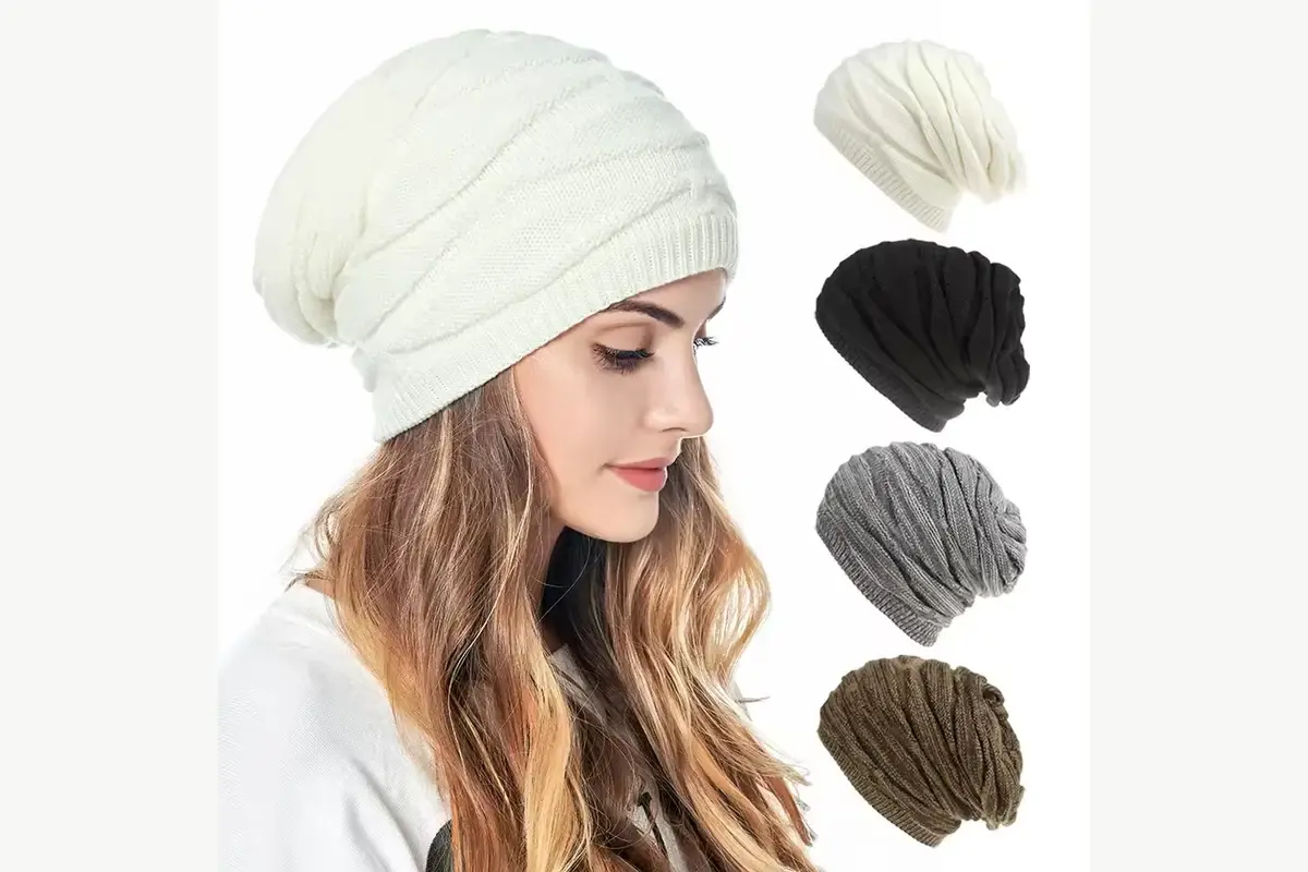 Model wearing a cream slouchy knit beanie with a relaxed rear drop
