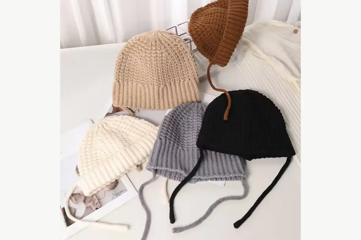 Brown and cream knit beanies arranged to compare their shapes