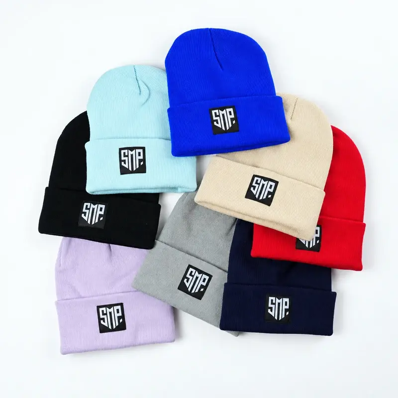 Nine colored cuffed beanies with varied woven patch artwork