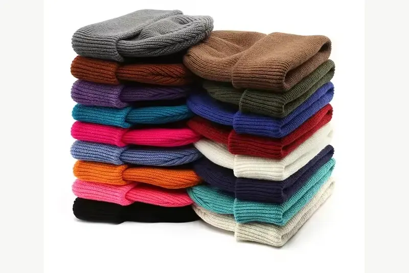 Stack of cuffed knit beanies in varied yarn colors