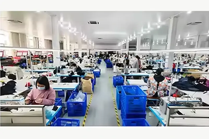 Workers sewing hats at stations in a production workshop
