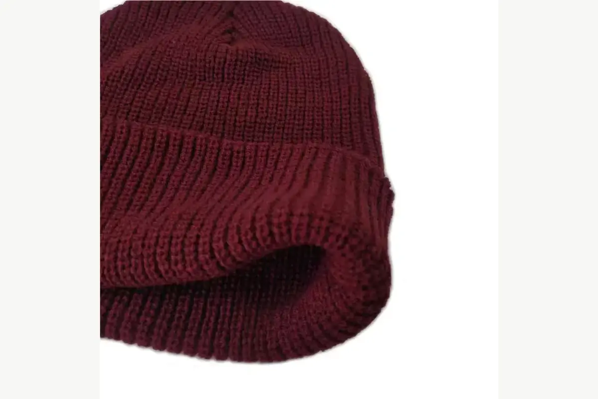 Close view of a burgundy ribbed beanie showing the folded cuff and inside knit