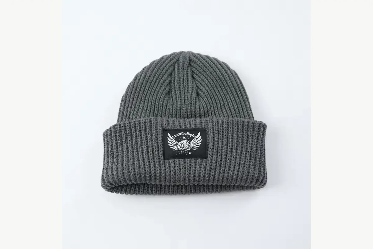 Gray ribbed fisherman beanie with a square woven patch on the cuff