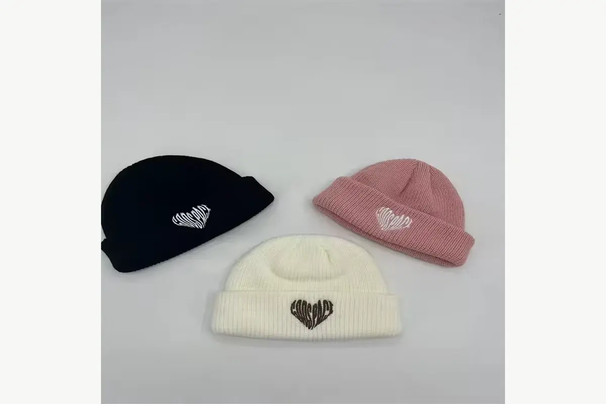 Three short cuffed beanies with different small embroidered motifs