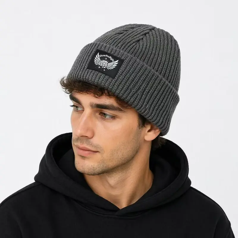 Man wearing a gray ribbed fisherman beanie with a square cuff patch