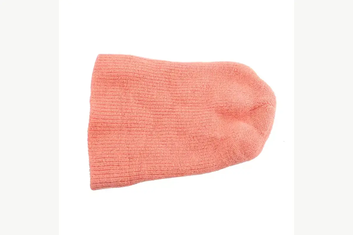 Peach slouchy beanie shown from the rear side to reveal crown drop