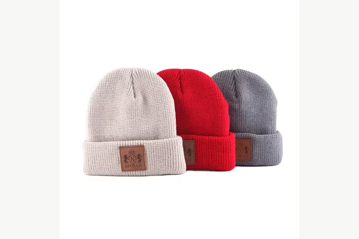 Cream ribbed knit beanie with a small brown front patch