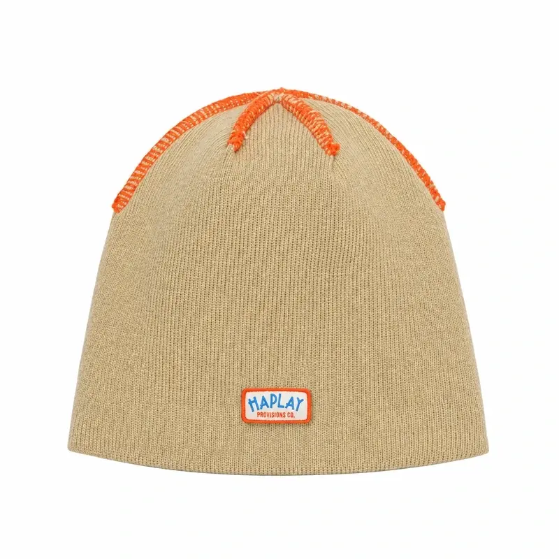 Beige ribbed cuffless skull cap beanie with woven patch, front view
