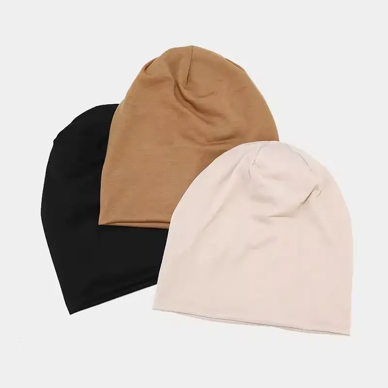 Black, tan and cream cuffless knit caps shown together