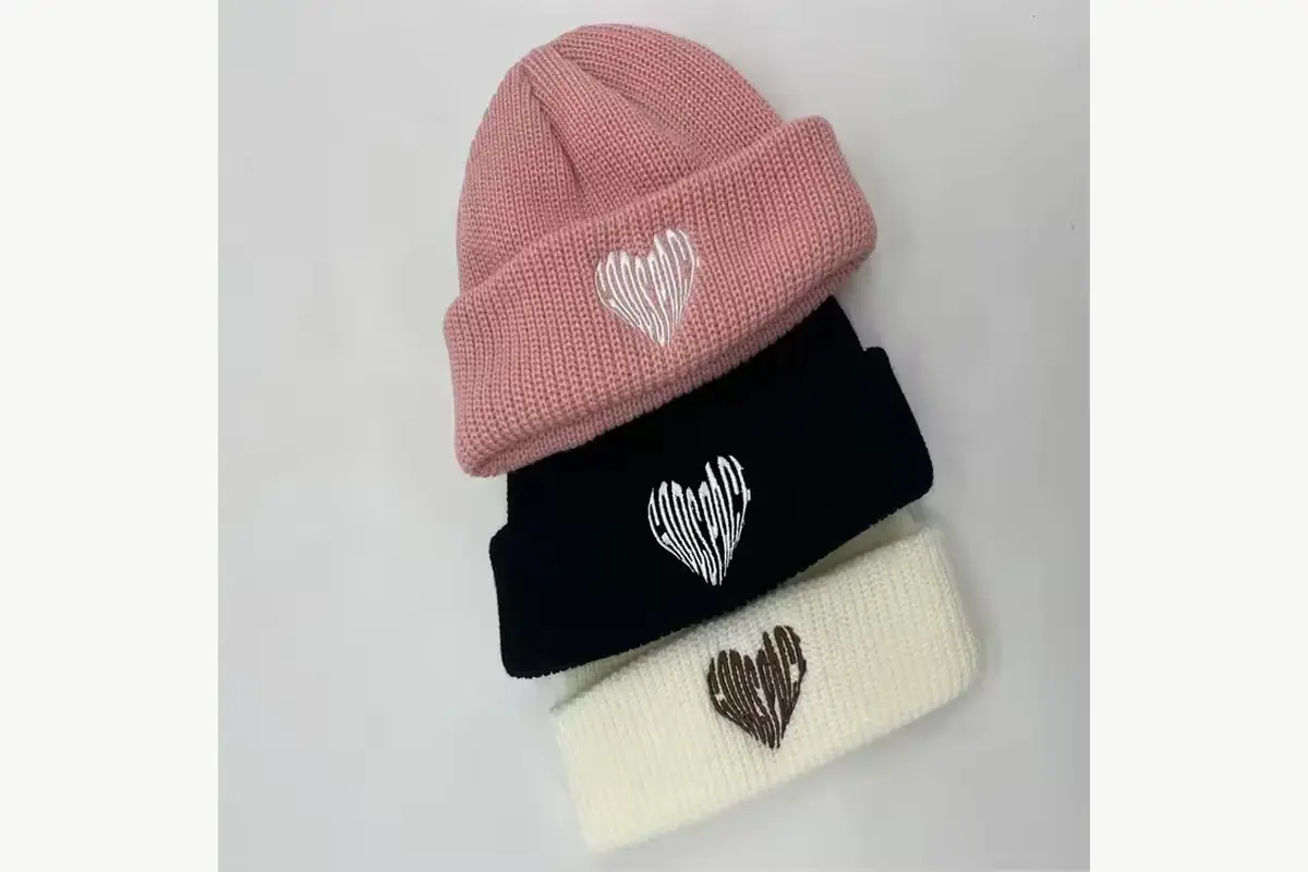 Pink, black and cream short beanies with small embroidered motifs