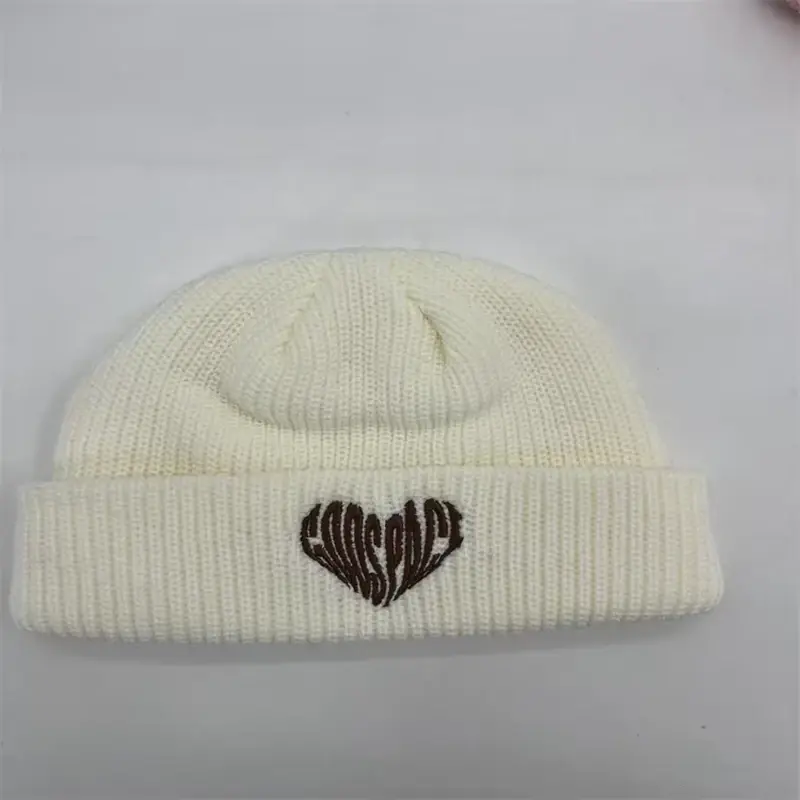 Cream short cuffed beanie with a small embroidered heart motif