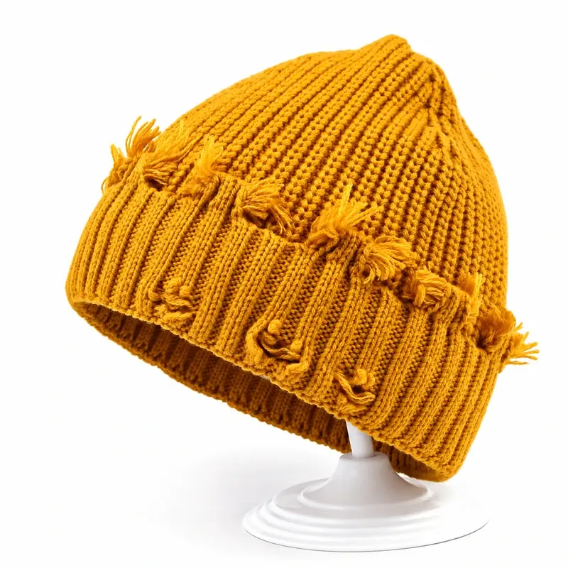 Mustard chunky cable-knit cuffed beanie with pom on a white display stand