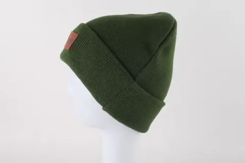 Dark green ribbed cuffed beanie with a side label