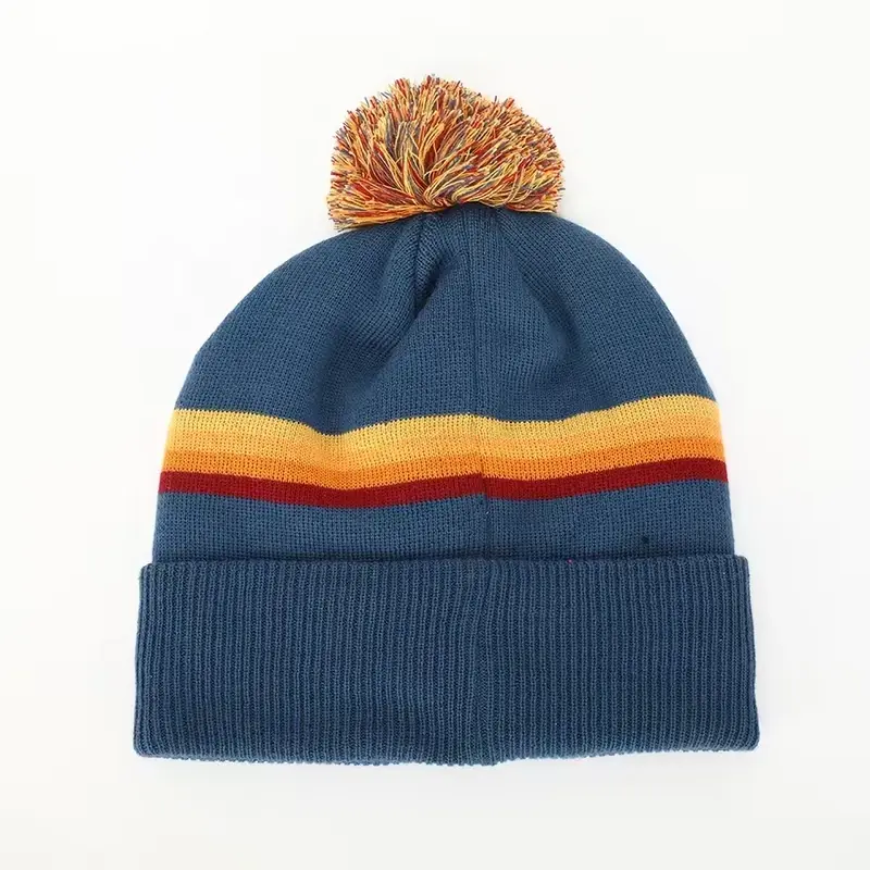 Back view of a blue striped yarn pom beanie