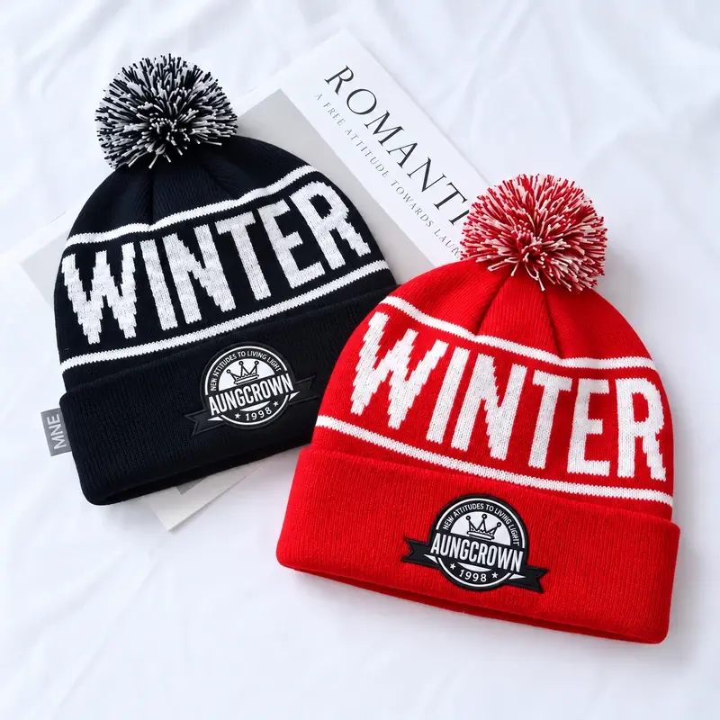 Red and navy pom-pom beanies with snowflake jacquard and WINTER lettering